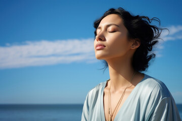 photo of woman praying with bluesky on the sea with blurred vision.