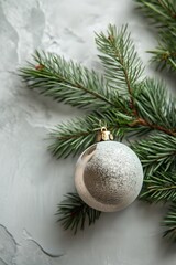 Silver Christmas ornament and frosted pine branches on white background. Christmas and New Year festive concept. Template for greeting card, invitation, banner with copy space.