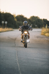 A biker rides a cafe racer on the highway