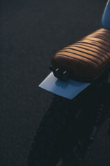 A close-up of a stylish cafe racer in the rays of the setting sun.