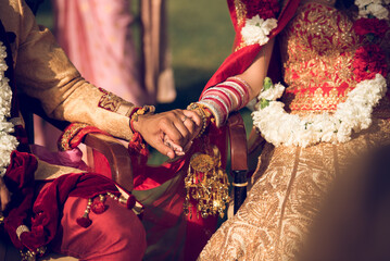 Hindu wedding couple holding hands in traditional attire