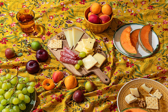 Colorful summer picnic spread with fruits and cheeses