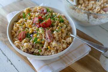 Vegetarian pasta salad with onions, pickles, corn and tomatoes