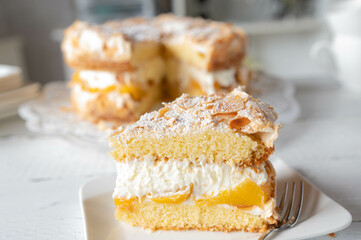 Piece of meringue cake with peaches and whipped cream