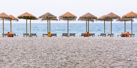 Sombrillas y tumbonas preparadas en una playa