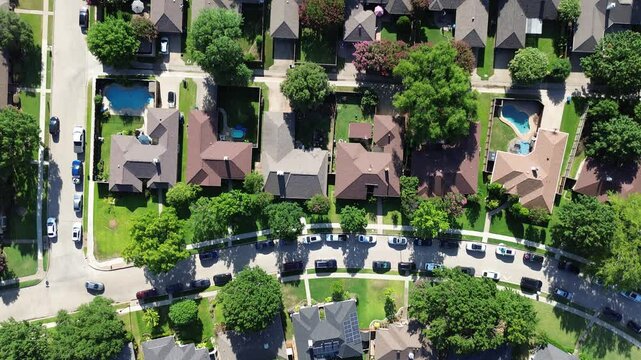 Busy neighborhood street long lined of parked cars row of large upscale two story detached houses with swimming pool, well-trimmed landscape in Coppell, Dallas Fort Worth metroplex, flyover view