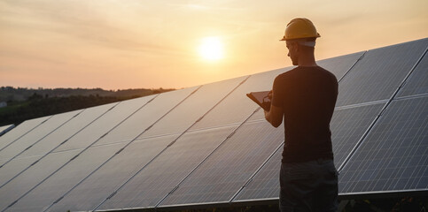 Engineer working at solar panels factory outdoor - Photovoltaic, renewable green energy and...