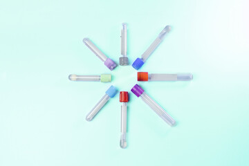 A group of plastic tubes with different colored caps are arranged in a circle. The tubes are of...