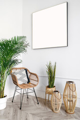 Rattan armchair with cushion, green plants on floor and picture on wall