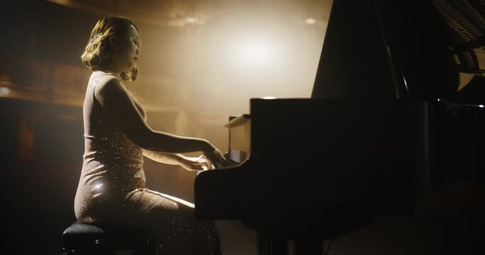 Portrait of a Talented Asian Pianist Captivating Audience with a Masterful Performance on a Grand Piano. Under Soft Stage Lights, Her Fingers Move Across the Keys, Creating Beautiful Classical Music