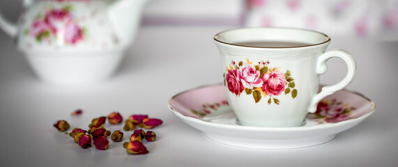 Tea rose flowers and cup of tea