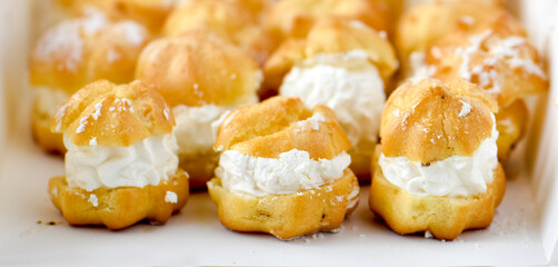 many cream puffs on a white box