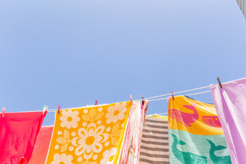 Colourful towels and swimmers hanging on washing line