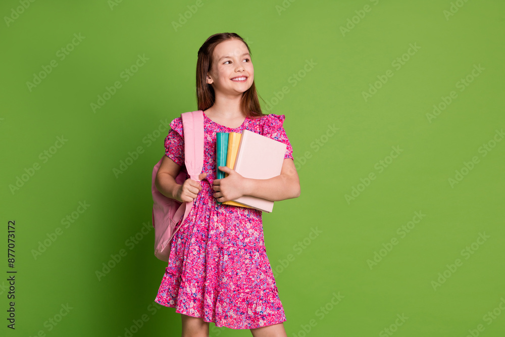 Wall mural portrait of lovely schoolgirl bag book look empty space wear pink dress isolated on green color back