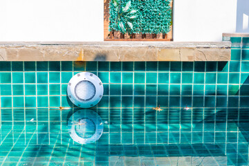 LED swimming pool light on tile wall, underwater illumination installation on concrete wall,...