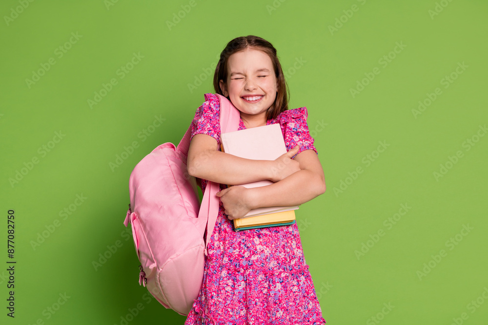 Canvas Prints Portrait of lovely schoolgirl closed eyes hug book wear pink dress isolated on green color background