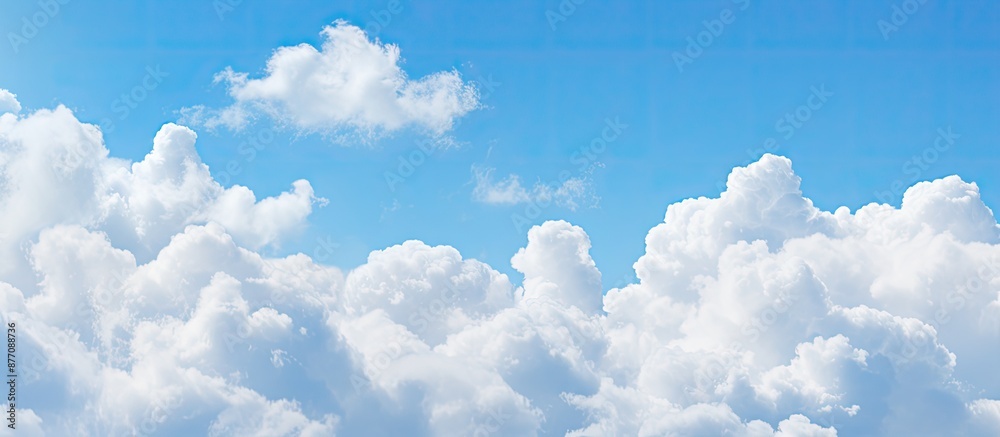 Poster soft-focused white clouds against a blue sky background with copy space image.