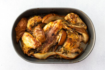 Baked chicken with pears and thyme, oval dish with baked chicken parts