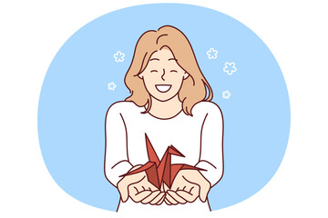 Woman with origami crane in palms wants to draw attention to problem of wildlife and extinction of animals from red book. Positive smiling girl holding origami bird for creative hobby concept