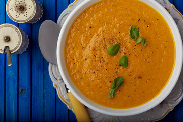 creamy carrot soup garnished with herbs and seasoning.