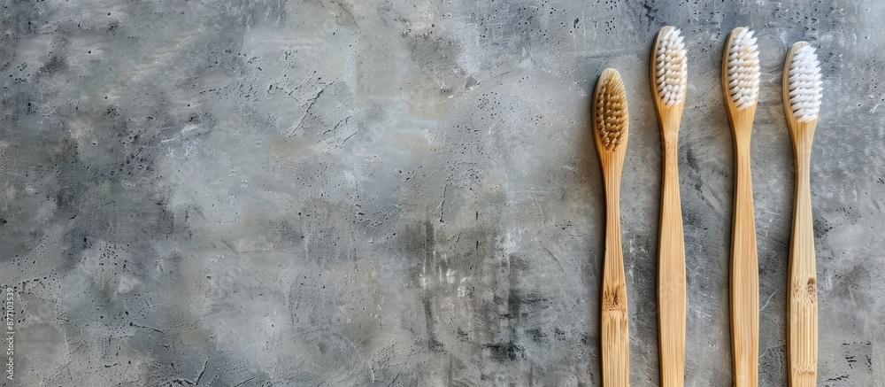 Poster Bamboo toothbrushes arranged on a gray stone surface with space for text or images, creating a minimalist bath background.