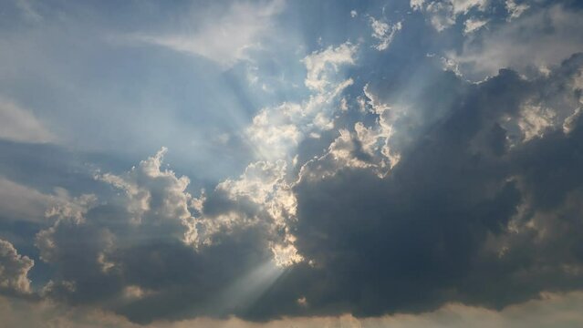 Rolling puffy clouds are moving, white and dark clouds time lapse. Clouds running across the blue sky with sunlight. 4k Timelapse footage of white clouds with blue sky in background.