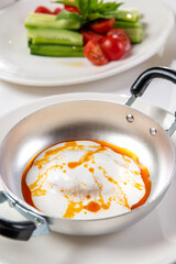 Poached egg Turkish name Cilbir, a classic Turkish dish, on a metal plate