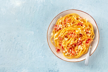 Carbonara pasta dish, traditional Italian spaghetti with pancetta and cheese, with a fork, shot from above with a place for text