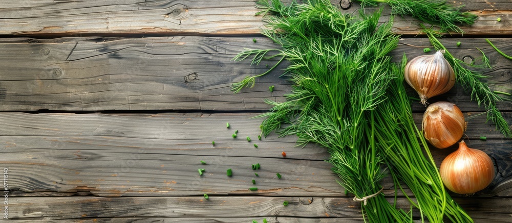 Poster top view of green dill and onion on a rustic wooden table with copy space image.
