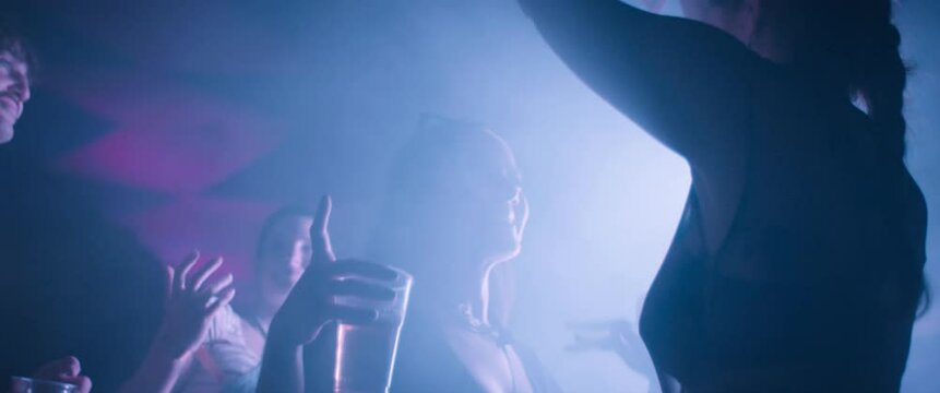 Friends having a good time at a music festival. They are dancing and enjoying their time together. Captured using an anamorphic lens and presented in the 2.39:1 CinemaScope aspect ratio.