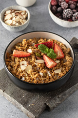 Homemade granola with fresh strawberries and mint, for a nutritious breakfast. Healthy food