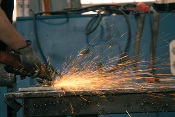 Detail of heavy industry manufacturing, sparks come out of a metal working welder.