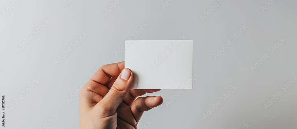 Fototapete mockup showcasing a blank business card held in hand against a white backdrop, featuring a layout fo