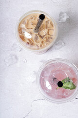 Two plastic glasses with drinks with ice. Trendy summer drinks with tapioca bubbles