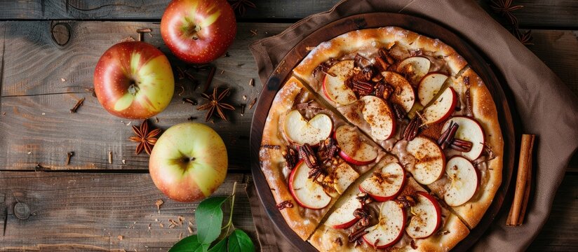 Apple, cinnamon, and chocolate pizza dessert on a wooden backdrop, displayed from above with available copy space for an image.