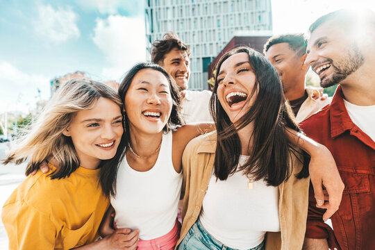 Multiethnic friends having fun walking on city street - Group of young people enjoying summer vacation together - Friendship concept with guys and girls hanging outside on a sunny day