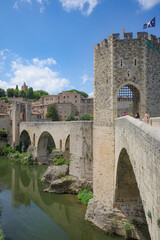Obraz premium Girona, Spain - 7 July, 2024: The medieval Pont Vell bridge crossing the River Fluvia at Besalu, Catalonia