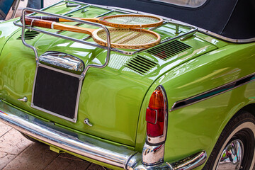 Vintage Green Car with Retro Tennis Rackets on Luggage Rack