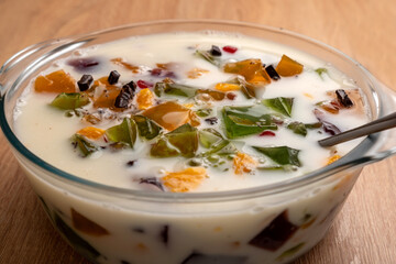 Pour milk and yogurt into a bowl with gelatin cubes. Preparation of gelatin desserts.