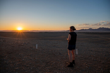 person witnessing a sunrise in sossusvlei, namibia