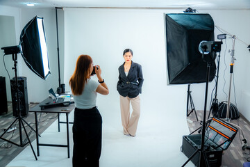 Beautiful young model in photo studio with photographer and makeup artist