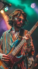 Obraz premium Stylish Young Bassist Performing at a Rock Music Festival in Striped Shirt, Sunglasses, and Jewelry. Musician Playing Under Colorful Stage Lights. Low-Angle Close-Up Portrait. Party, Festival, Youthfu