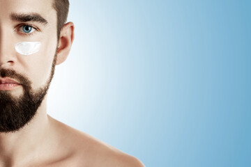 Fototapeta premium Man applying face cream to his face. Skincare and personal grooming routines for men.