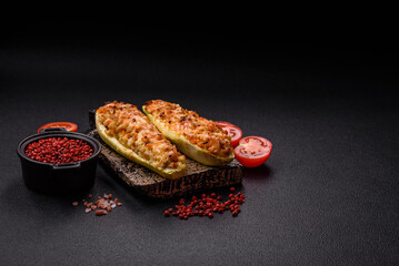 Zucchini halves baked with cheese, tomatoes, meat or meat substitute