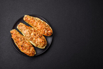 Zucchini halves baked with cheese, tomatoes, meat or meat substitute