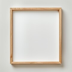 Fototapeta premium thin light wooden picture frame, blank white canvas on white beige empty plain background