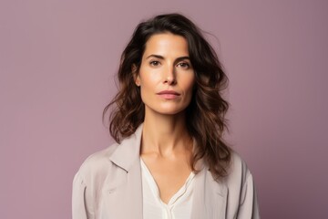 Fototapeta premium Portrait of a beautiful brunette woman on a purple background.