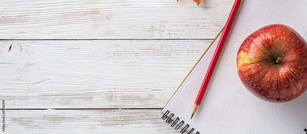 Fototapete Back to school concept with red apple and pencil placed on a notebook against a white wooden table background creating a composition perfect for a copy space image