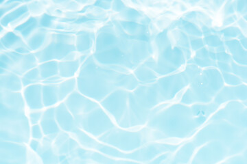 Obraz premium Blue water with ripples on the surface. Defocus blurred transparent blue colored clear calm water surface texture with splashes and bubbles. Water waves with shining pattern texture background.