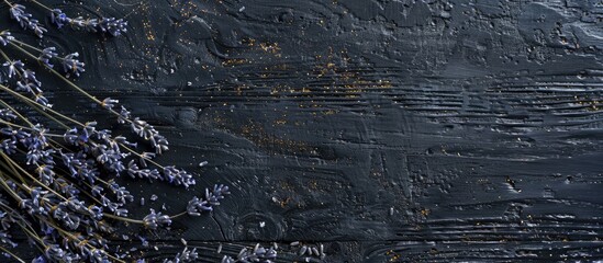 Fototapeta premium Black wooden surface with dried lavender flowers showcasing copy space image